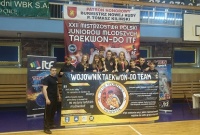 Zdjęcie grupowe zawodników Wojownika ze swoim banerem reklamowym